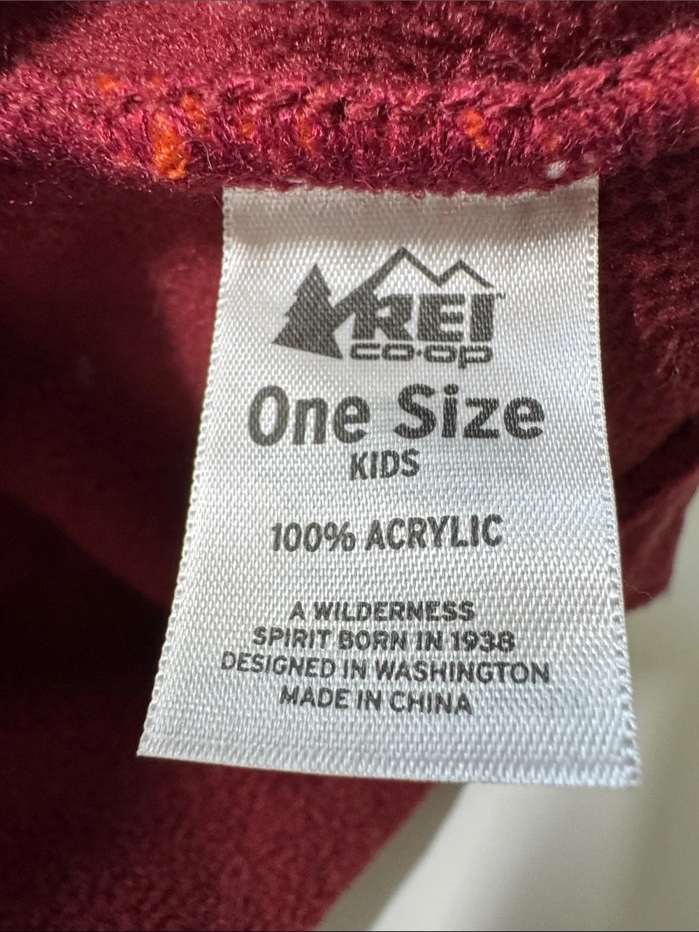 Kids REI acrylic knit beanie hat with pompom and ear flaps.